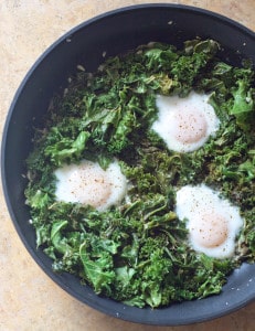 Simmered Eggs in chicken stock sautéed Kale. A hearty healthy way to start your day with plenty of greens!