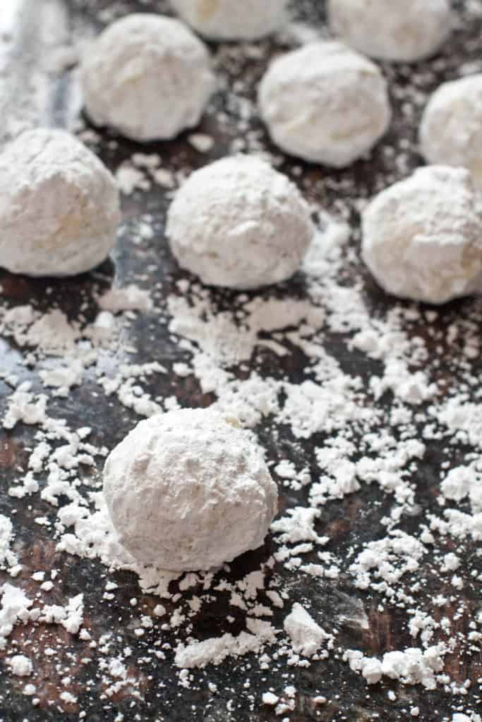 a sugar coated counter and white butter ball cookies.