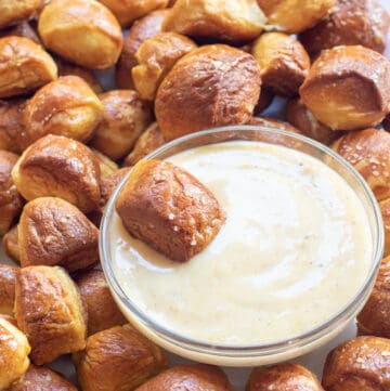 a plate of baked pretzel bites with a bowl of honey mustard sauce.