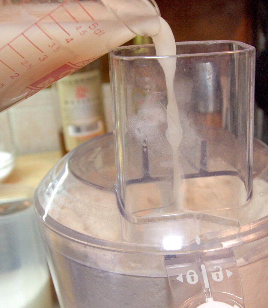 a mixture being poured into a food processor