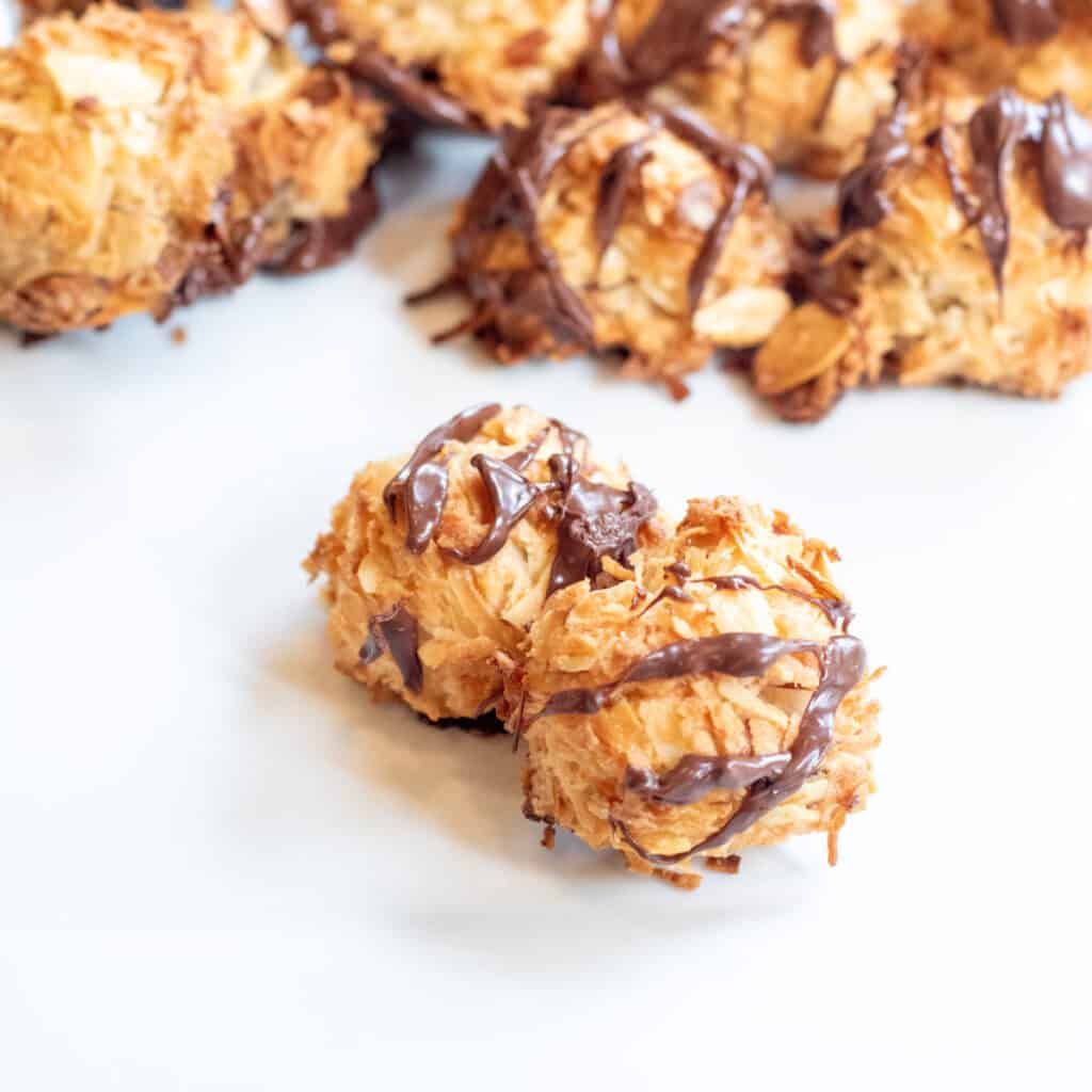 two stacked macaroons on a plate in front of other maracroons.