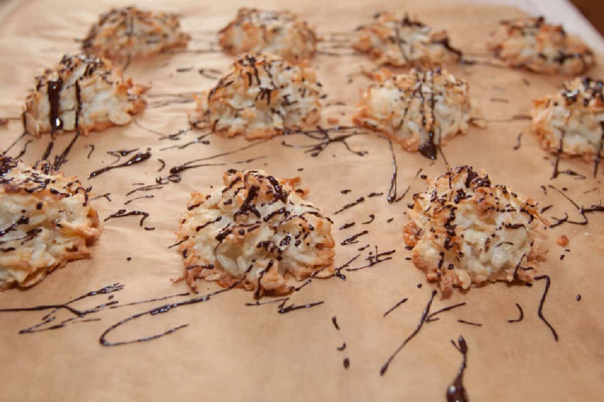 a tray of macaroons drizzled with chocolate.