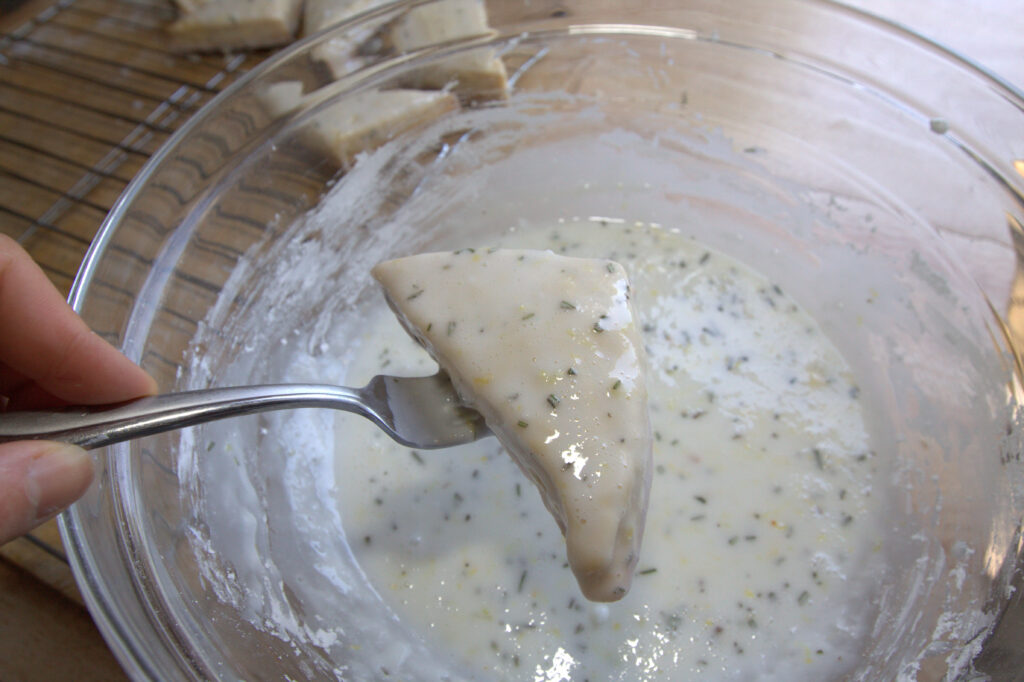 a fork holding up a glazed scone.