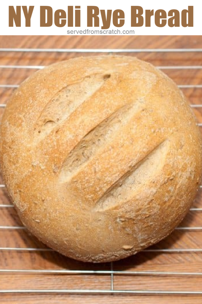 an overhead of a fresh baked round loaf of bread on a drying rack with PInterest Pin text.