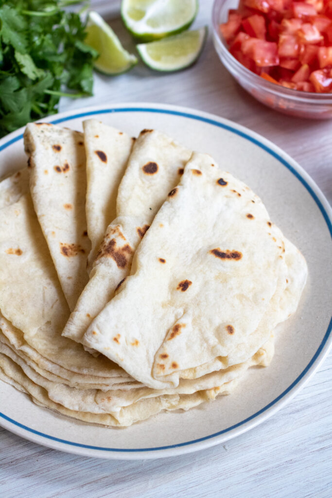 a plate of folded flour tortillas.