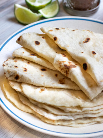 a plate of folded flour tortillas.