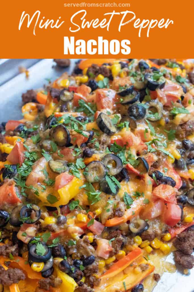 a baking sheet of mini peppers with ground beef, olives, black beans, corn, melted cheese, and fresh cilantro nachos with Pinterest pin text.