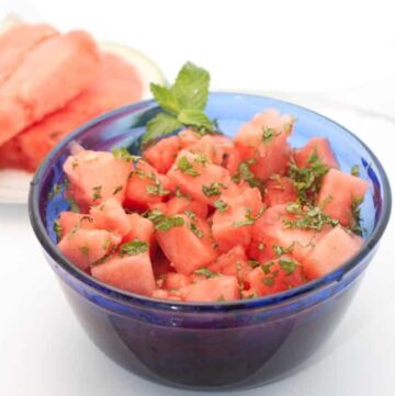 cut watermelon in a blue bowl with mint