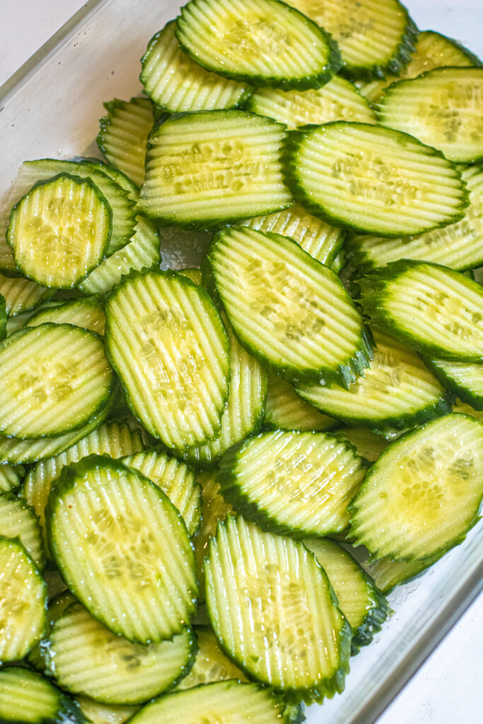 sliced pickles lined in a tray.