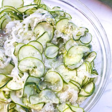 cucumbers, onions and sesame seeds in a bowl.