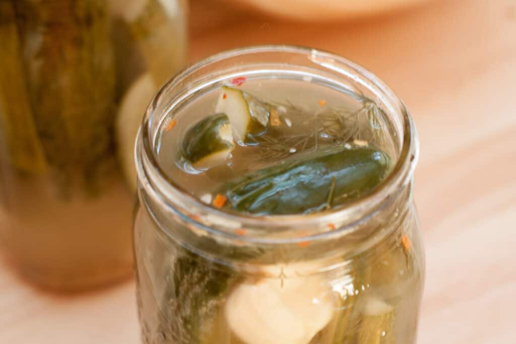 an open mason jar of dill pickles.