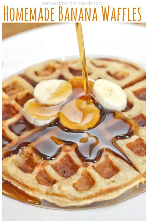 cooked banana waffles on a plate topped with bananas and maple syrup poured.