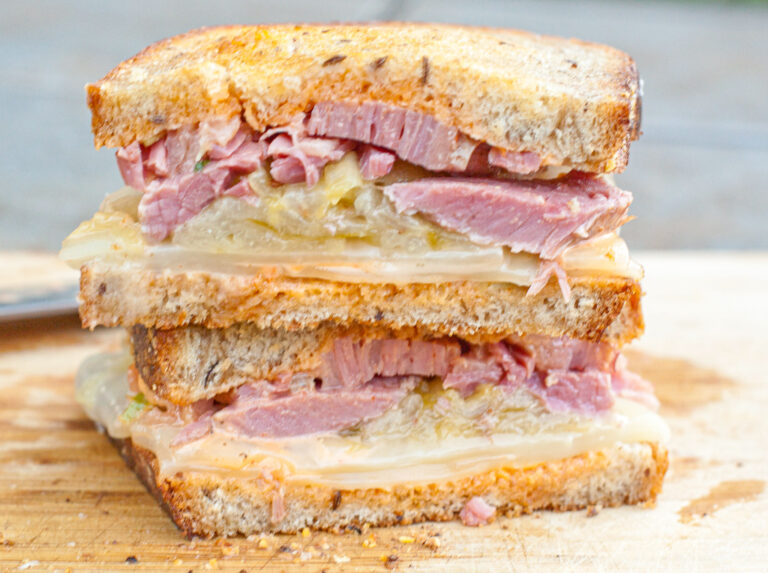 a halved and stacked corned beef sandwich.