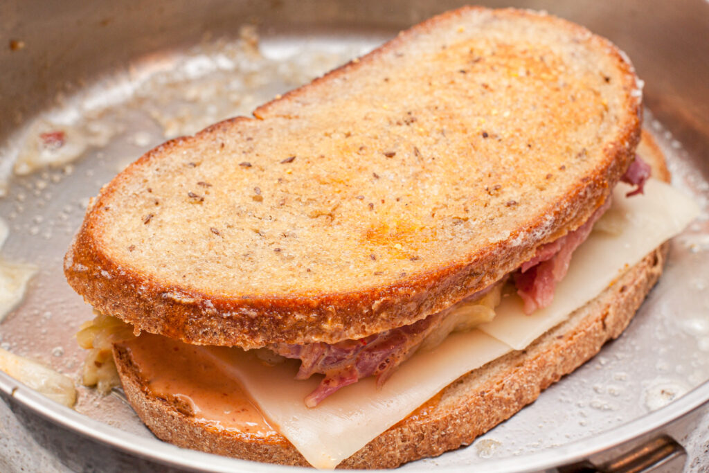 a rye bread sandwich grilling in a pan