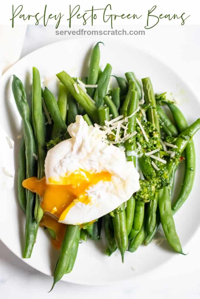 two plates with green beans and pesto and topped with a runny poached egg with Pinterest Pin.
