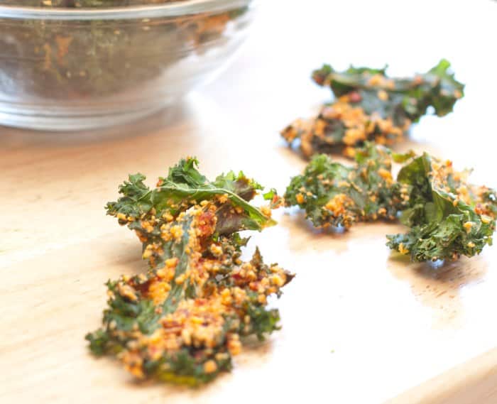 a couple of kale chips with a chunky blend coated on them.