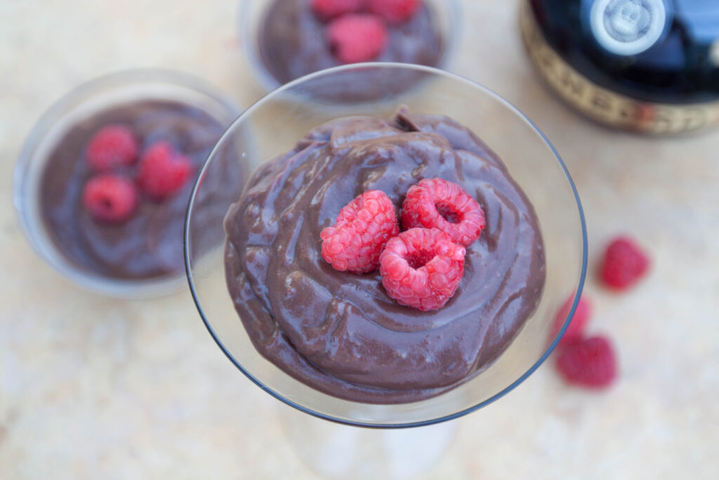 a martini glass with chocolate pudding and fresh strawberries.