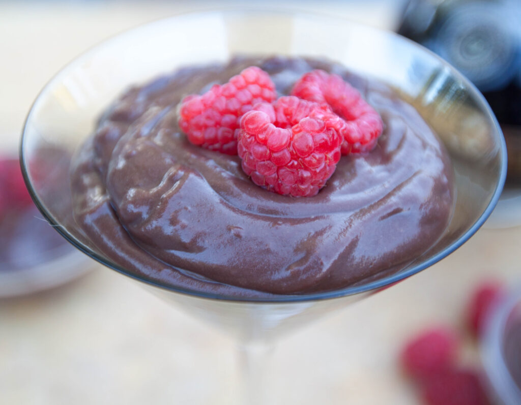 a martini glass with chocolate pudding and fresh strawberries.