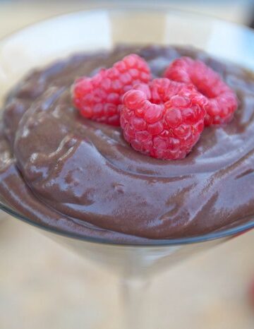 a martini glass with chocolate pudding and fresh strawberries.