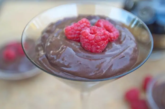 a martini glass with chocolate pudding and fresh strawberries.