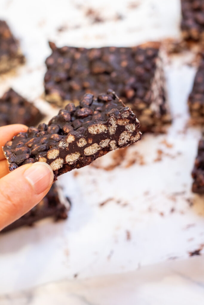 a hand holding a crunch bar