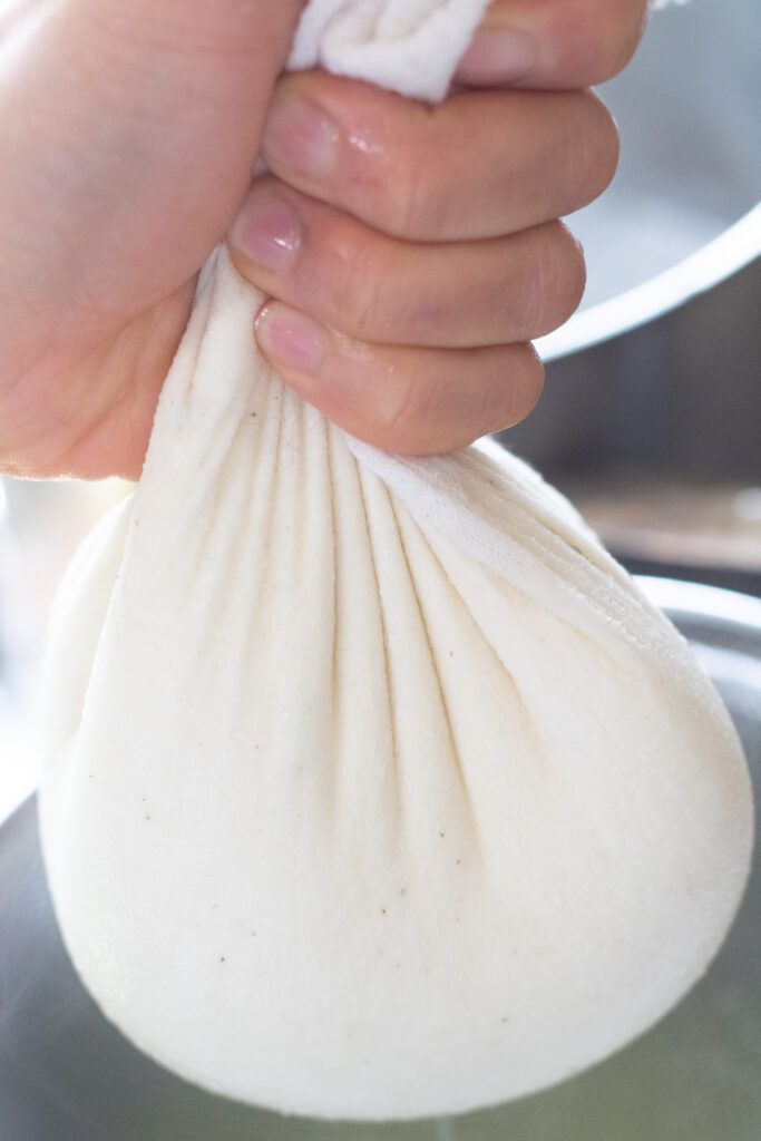 a hand holding a cheese cloth