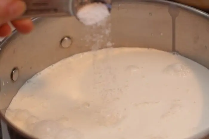 salt being poured into a pot.
