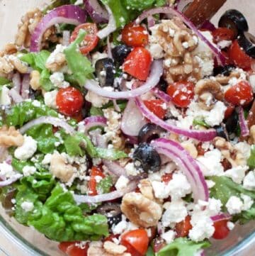 an overhead of a greek salad with walnuts.