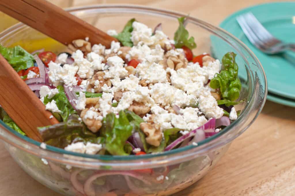 a large bowl of salad with tongs.