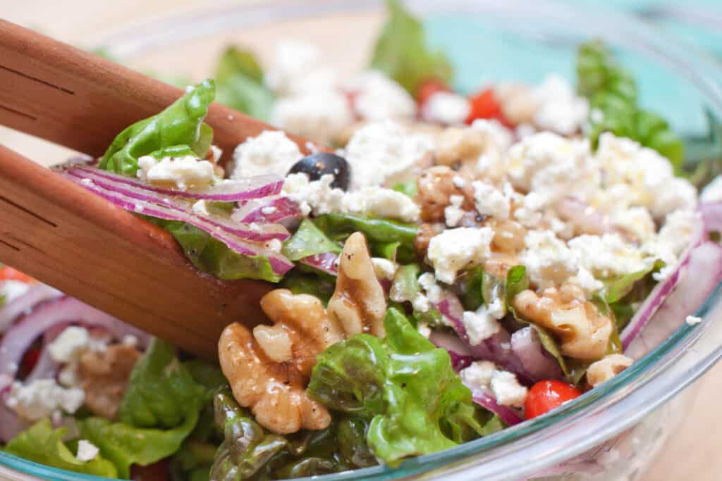 a bowl of salad being mixed.