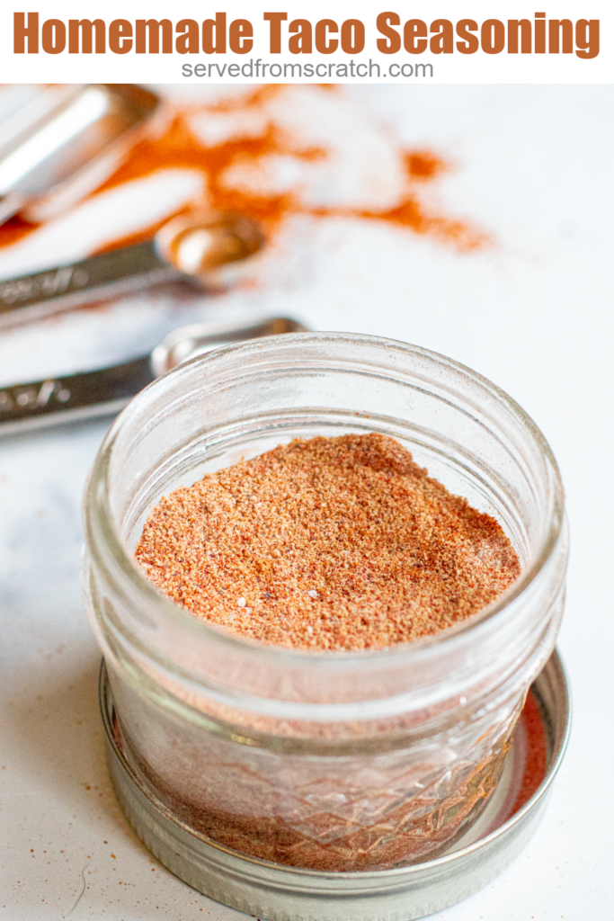 an open mason jar with taco seasoning with Pinterest pin text.