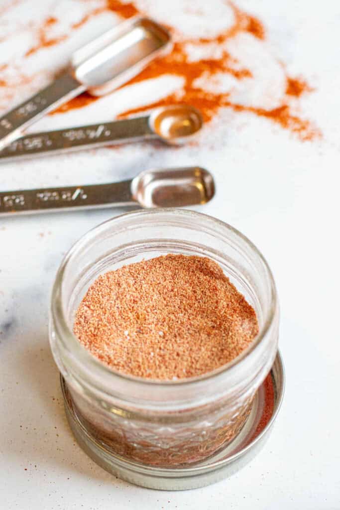 a small open mason jar open with taco seasoning.