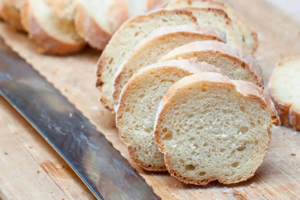 sliced baguette on cutting board.