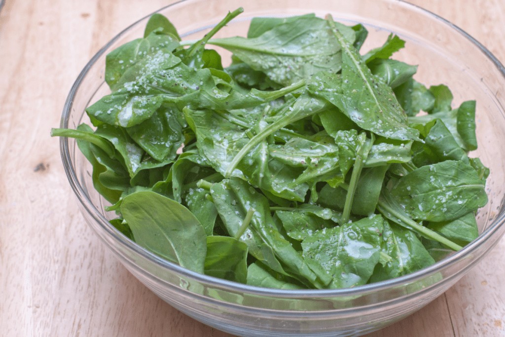 a bowl of dressed arugula.