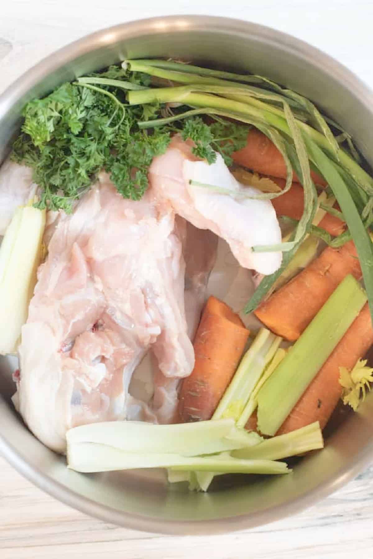 a pot of raw chicken and veggies.