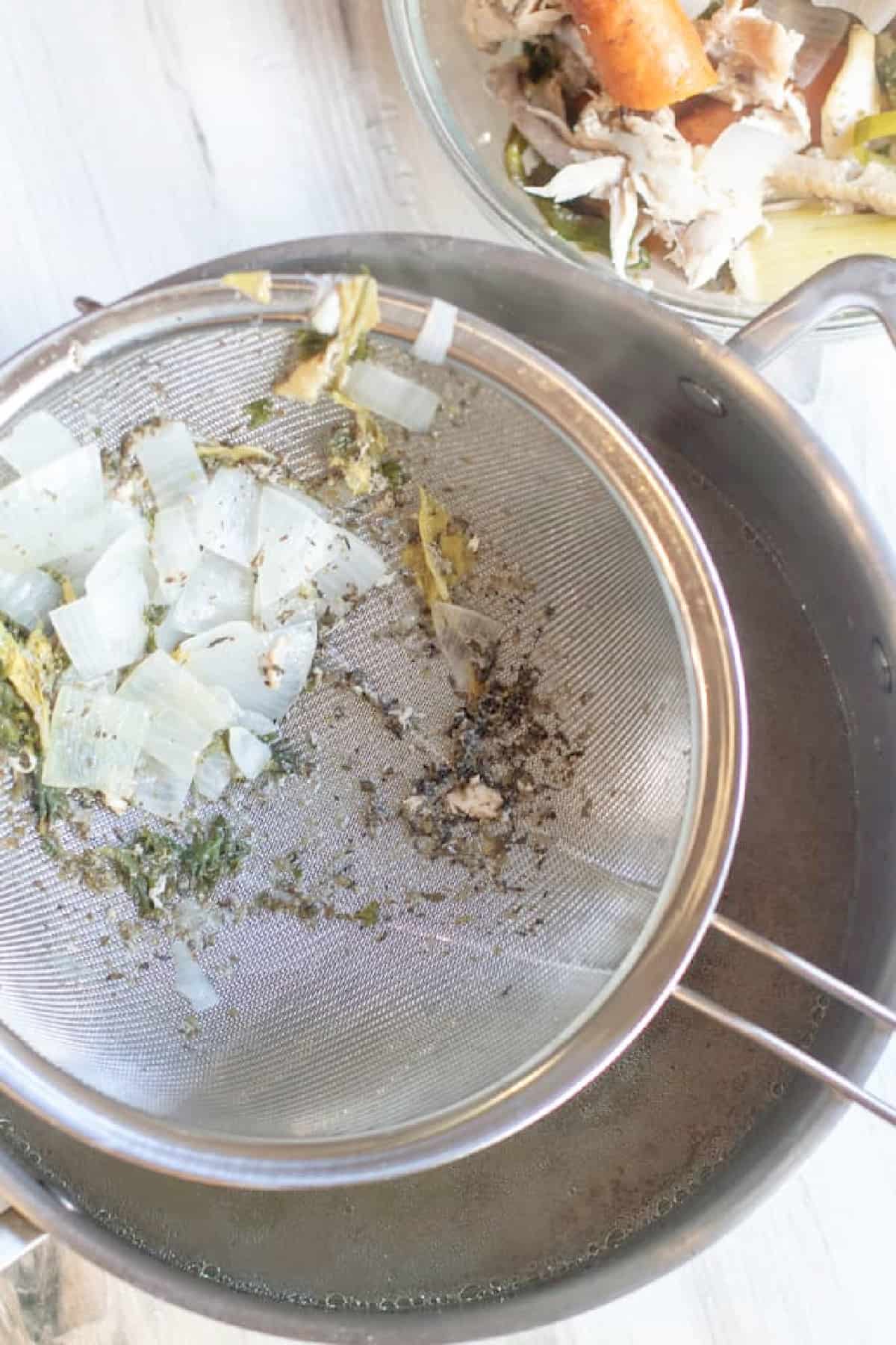 a sieve of veggies over a pot.