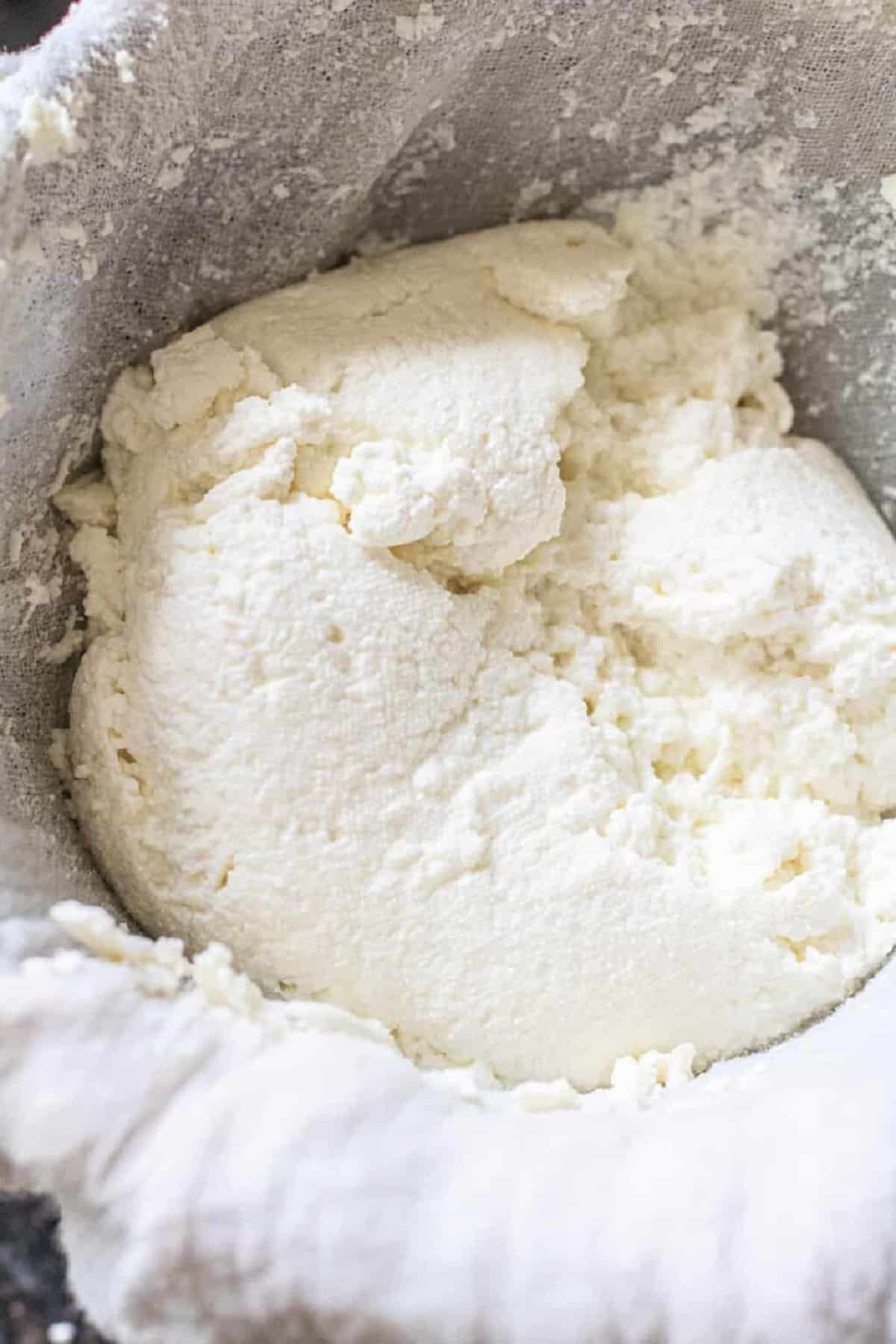 an open cheese cloth of fresh ricotta cheese.