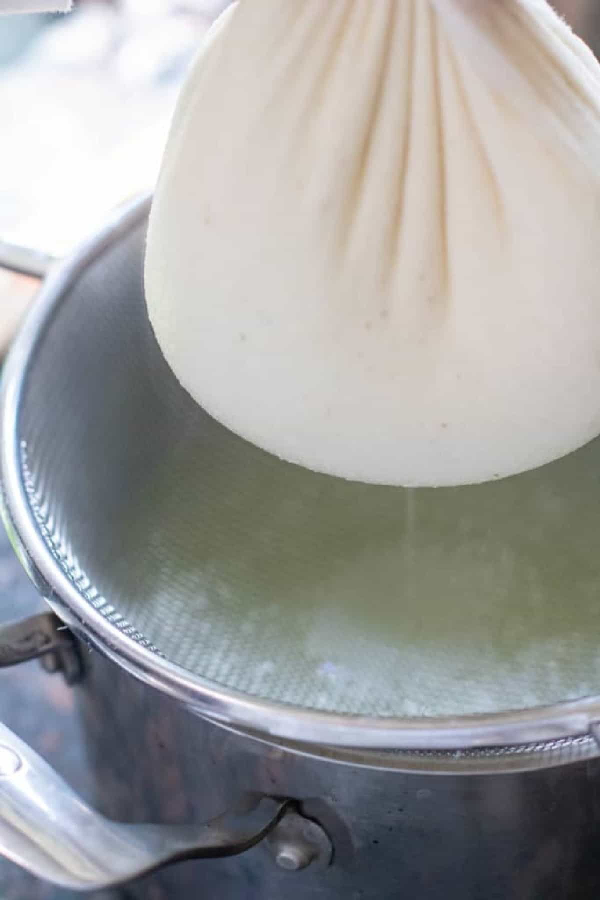 a full cheese cloth suspended over a pot.