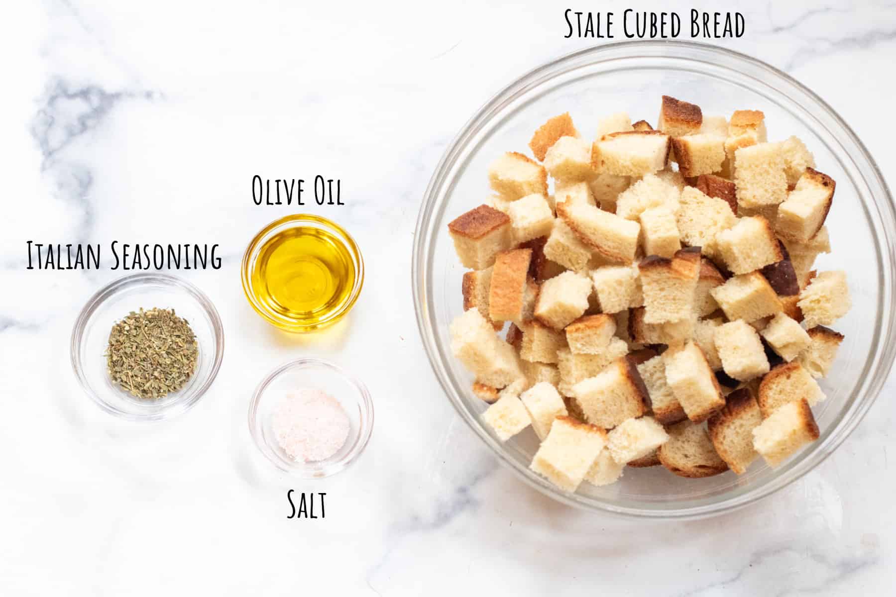a bowl of cubed bread, olive oil, salt, and Italian seasoning all labeled.