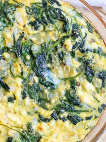 overhead of a crustless quiche with spinach and eggs.