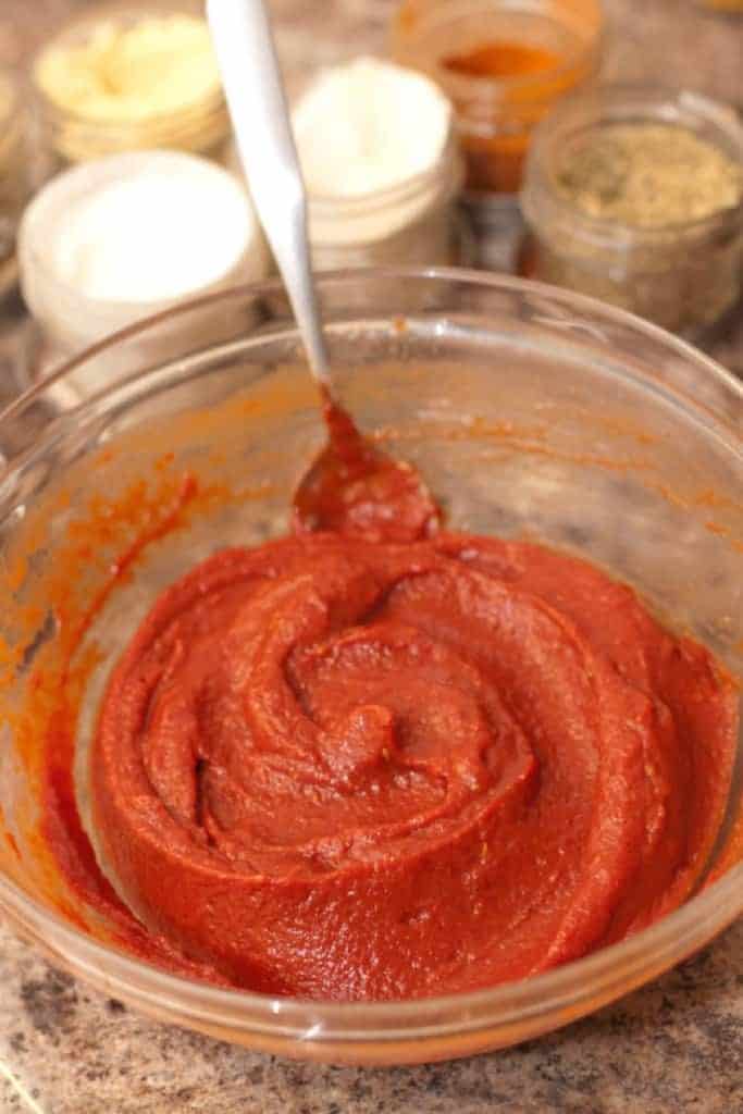 a bowl of mixed ketchup with a spoon.