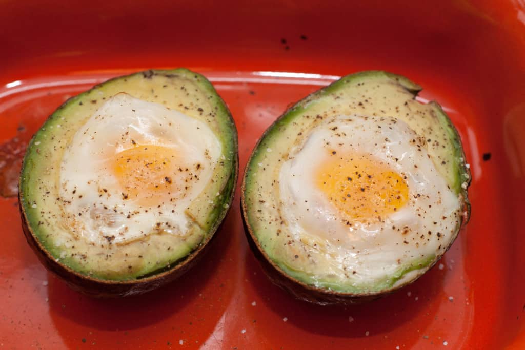 two avocado halves with baked eggs.