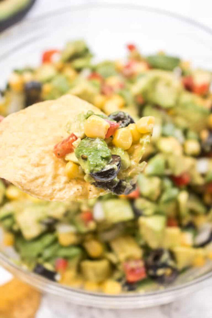 a chip holding some avocado dip.