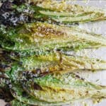 grilled romaine on a tray with Parmesan cheese.