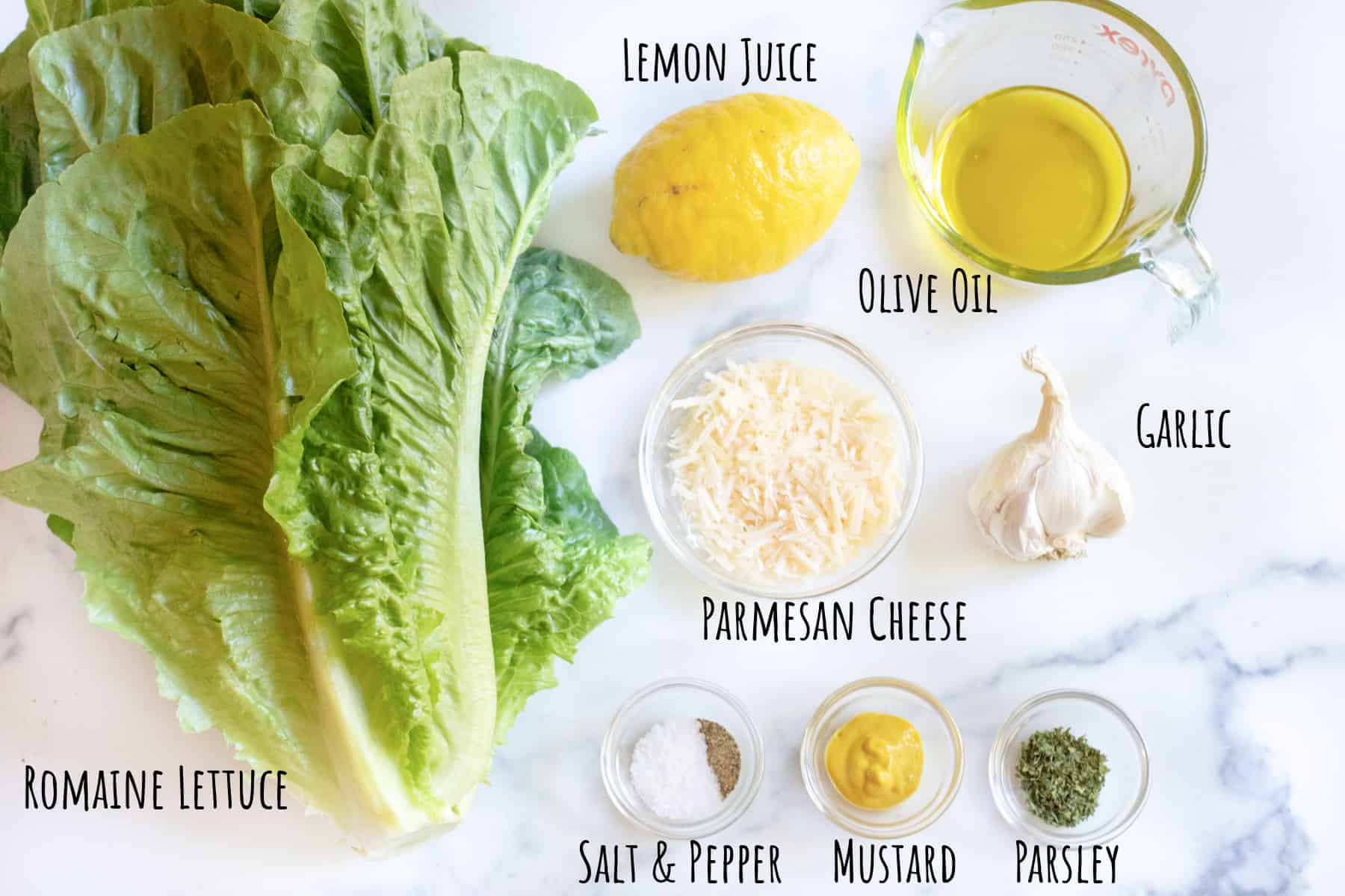 romaine, lemon, cheese, oil, garlic, salt and pepper mustard, and parsley in bowls.