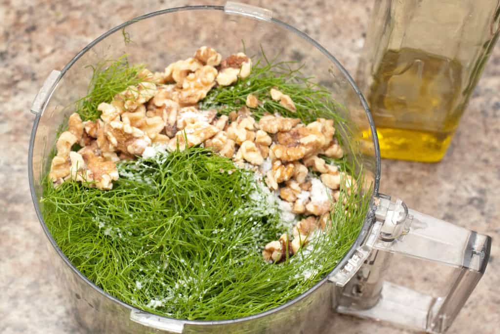 fennel fronds, walnuts, and salt in a food processor.