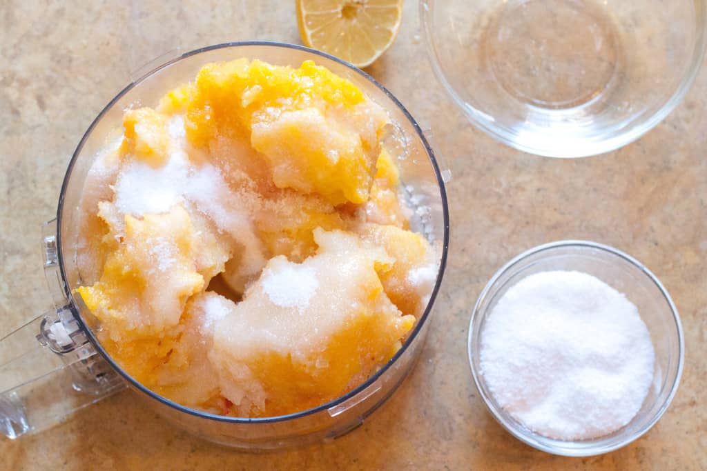 food processor with frozen peaches and sugar