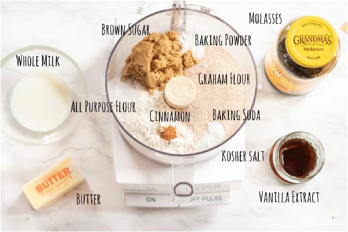 a food processor with ingredients in it for graham crackers with milk, butter, molasses, and vanilla.