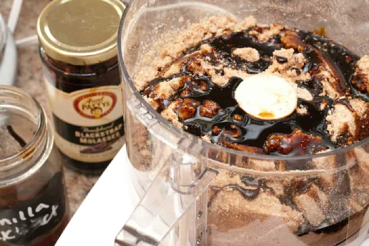 food processor with flours and molasses poured on top.