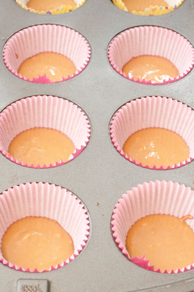 muffin tin lined with cups filled with peanut butter